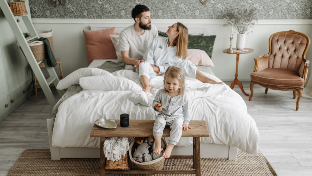 A young family enjoying a peaceful morning in their stylish bedroom setting.
